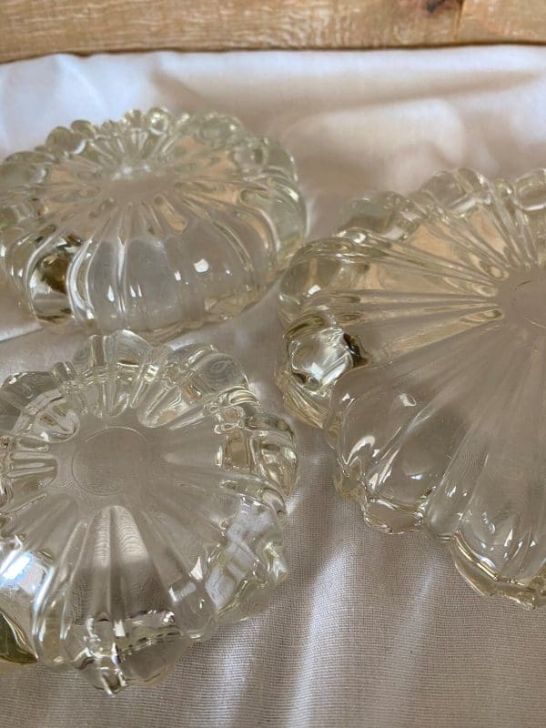 Vintage glass ashtrays set of three flower shaped bottoms close up