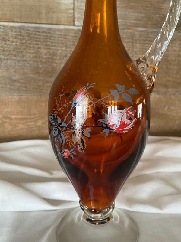 vintage amber glass decanter close of rose decor on front