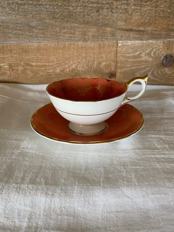 Aynsley bone china tea cup in burnt orange, white, gold trim and floral side view 2