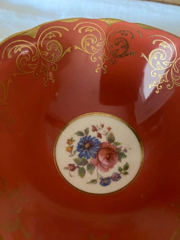 Aynsley bone china tea cup in burnt orange, white, gold trim and floral sucer close up