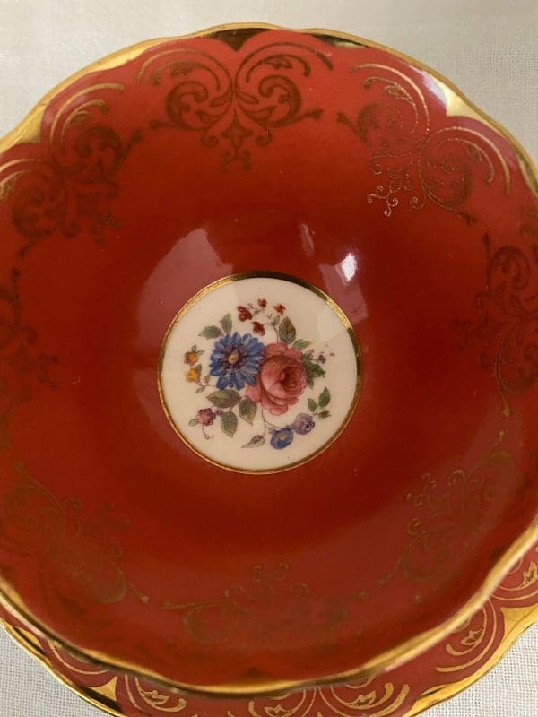 Aynsley bone china tea cup in burnt orange, white, gold trim and floral close up inside tea cup