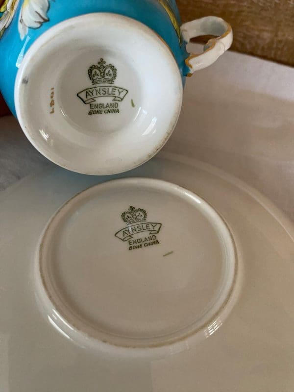 Aynsley England bone china tea cup 1930s in blue and yellow with flower. Bottom of tea cup and saucer