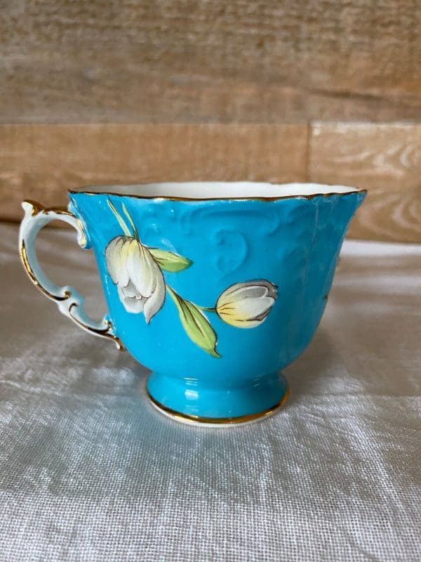 Aynsley England bone china tea cup 1930s in blue and yellow with flower. Closeup of tea cup