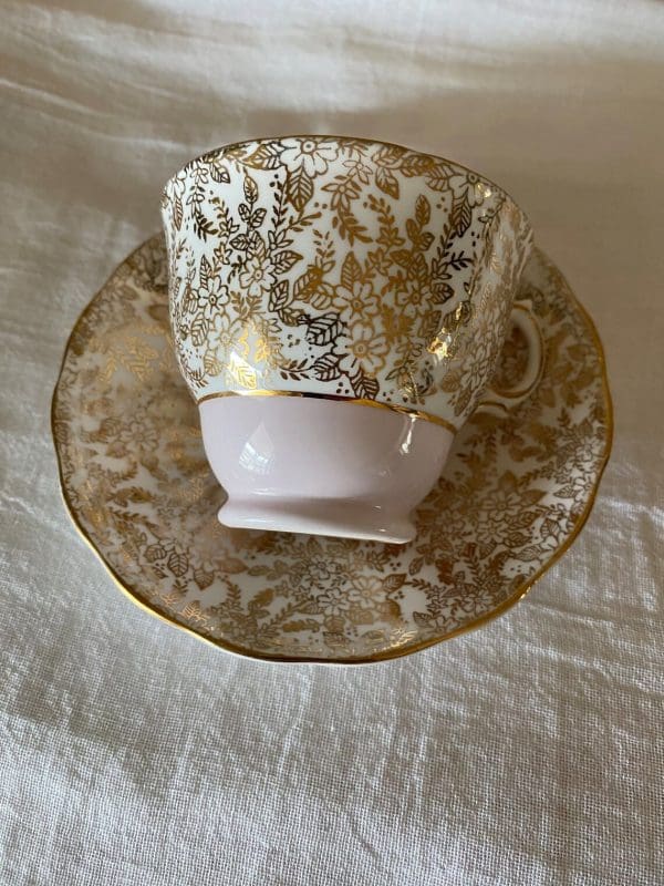 Colclough china tea cup pink, white and gold floral cup on side