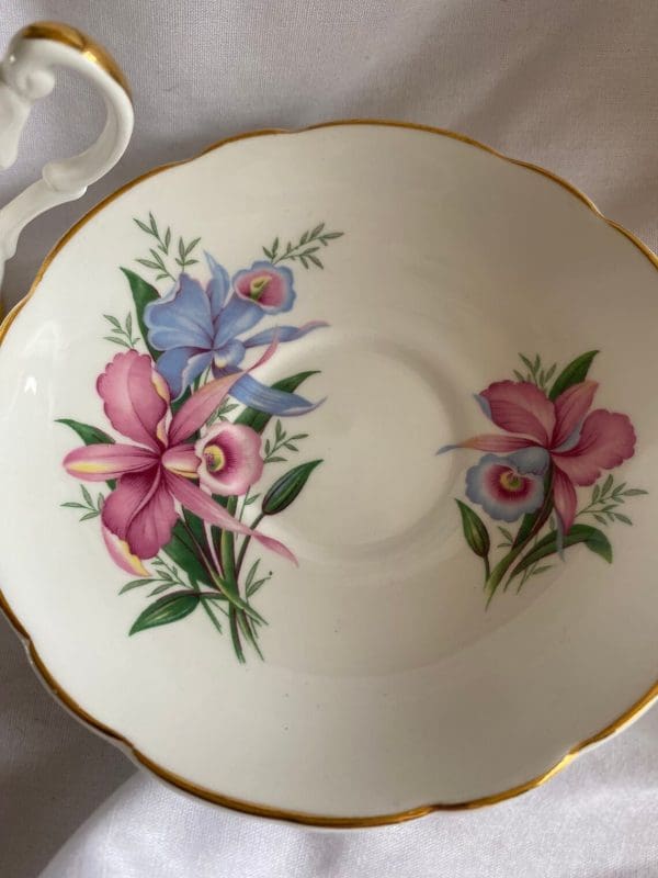 Consort tea cup with flowers design pink and blue daffodils gold trim closeup of saucer