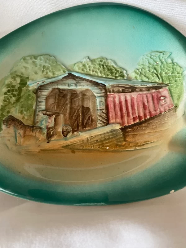 Porcelain ashtray vintage covered bridge depiction closeup one