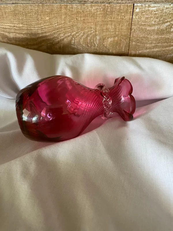 Rossi cranberry glass vase laying on side