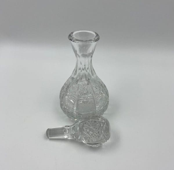 small crystal decanter with stopper in front