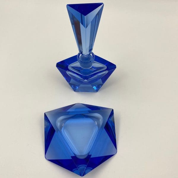 blue crystal perfume bottle top of trinket dish