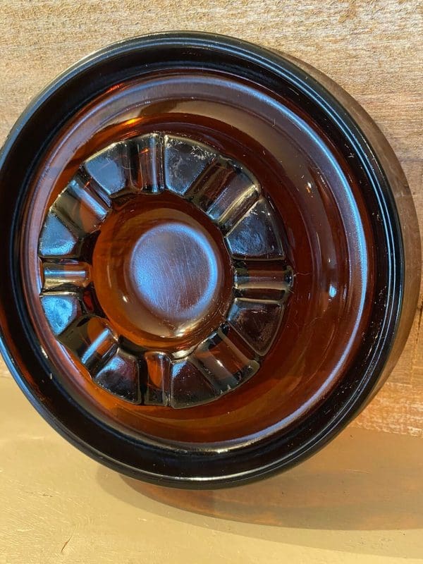 Vintage glass cigar ashtray dark amber, round close up standing view