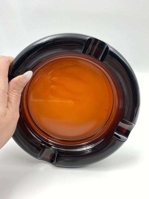 Vintage amber ashtray glass round on its side