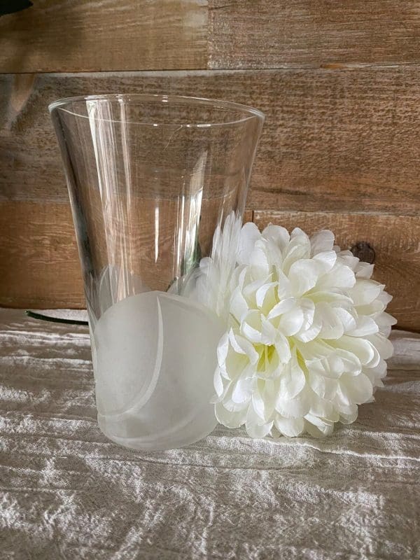 frosted glass vase next to large flower