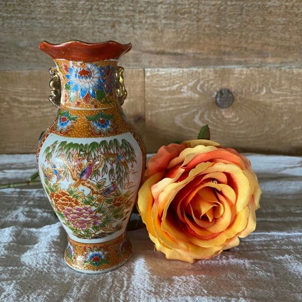 vintage bird vase beside flower