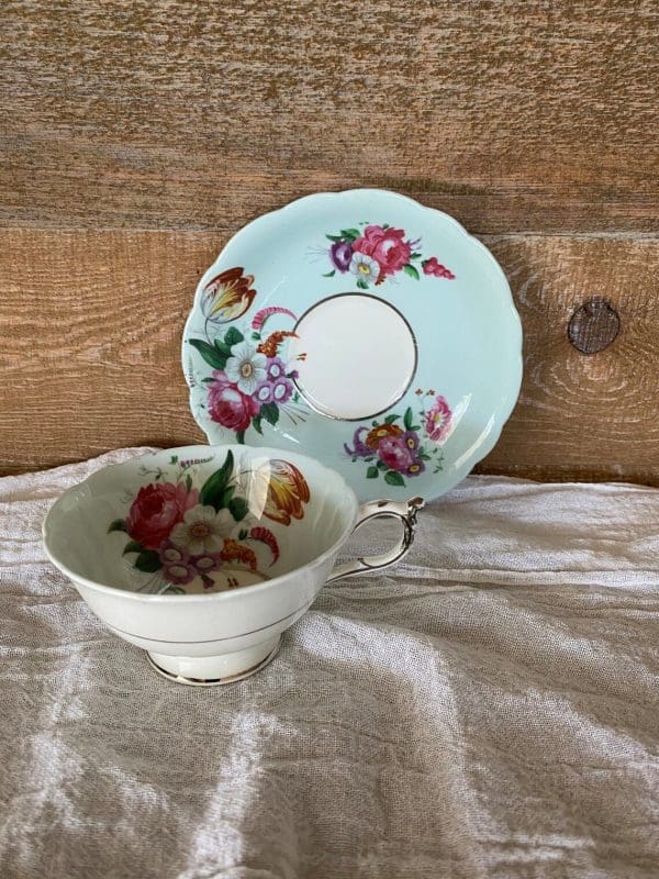 Paragon fine bone china tea cup and saucer with colorful flowers on blue backdrop view 2