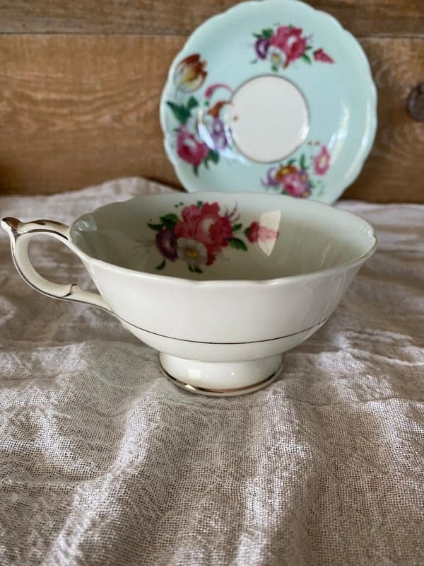 Paragon fine bone china tea cup and saucer with colorful flowers on blue backdrop forward view