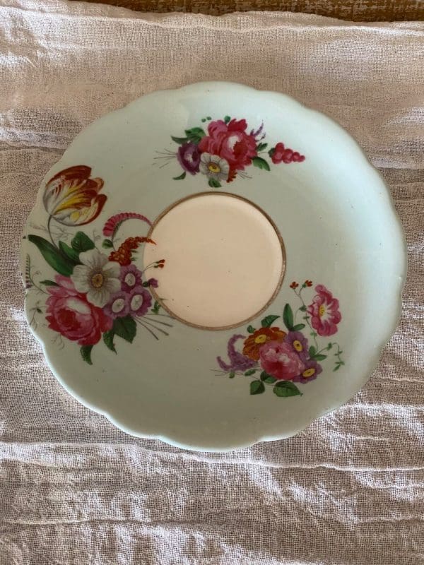 Paragon fine bone china tea cup and saucer with colorful flowers on blue backdrop closeup of saucer