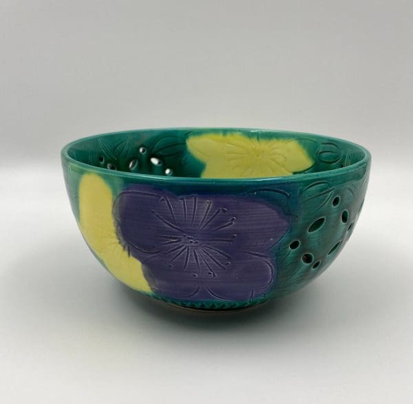 vintage green pottery bowl front with purple and yellow flowers