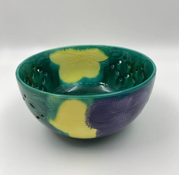 vintage green pottery bowl colorful yellow and purple flowers and pierced sides