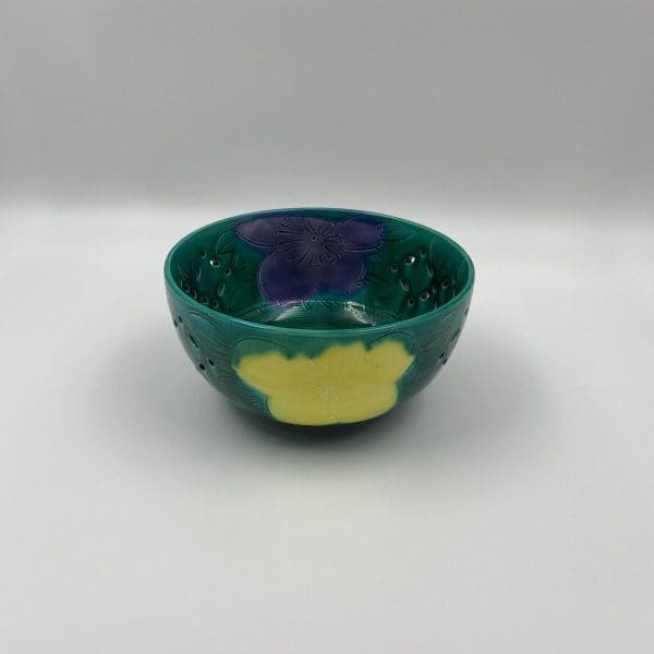 vintage green pottery bowl with yellow and purple embossed floral design