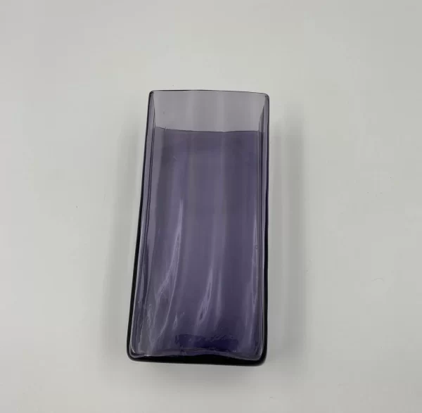 large purple glass vase laying on side