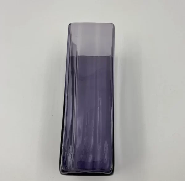 large purple glass vase laying