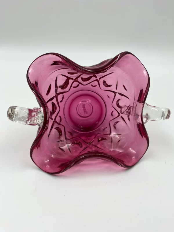 pink glass bowl on side showing the inside and applied clear glass handles