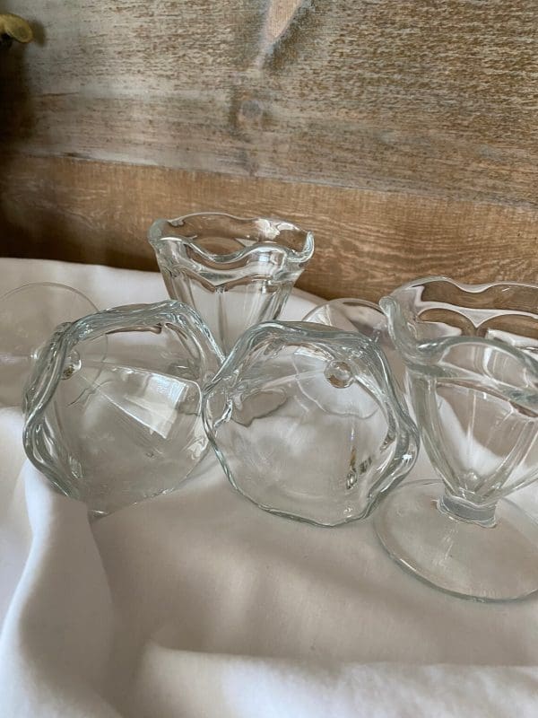 vintage glass sundae dishes laying on side and two standing to show shape