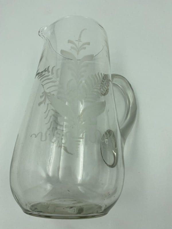 vintage glass pitcher on side showing etch detail