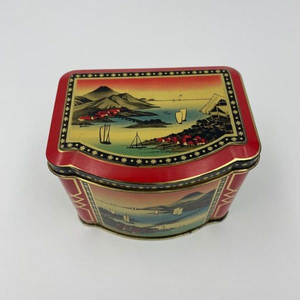 Japanese tea tin top with litho of water scene. Red Black Gold