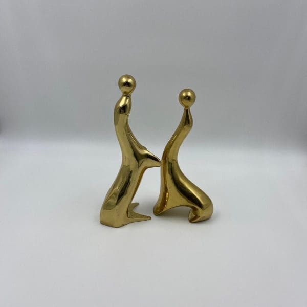 vintage brass figurines facing each other sea lions