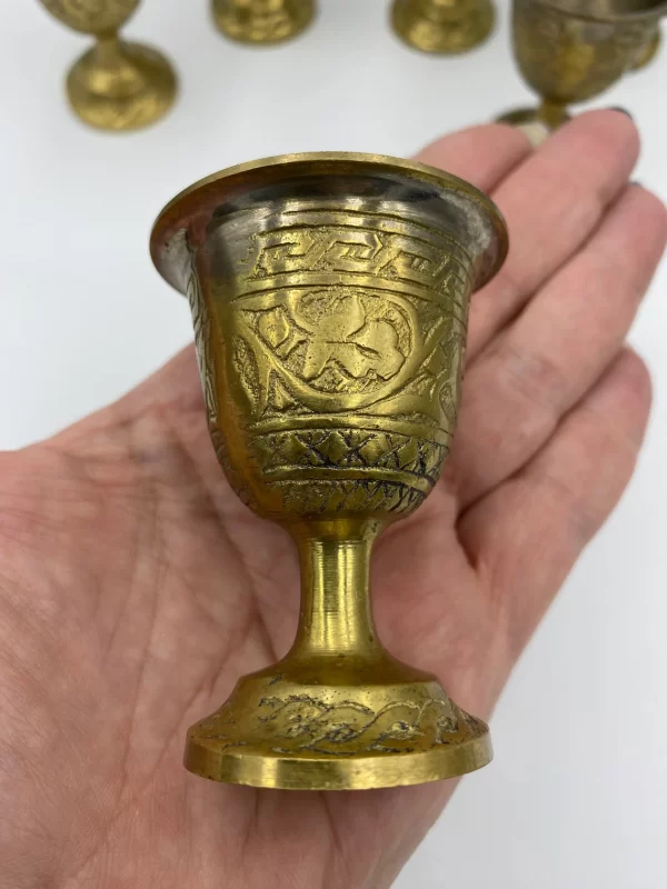 brass shot glasses in hand to show size