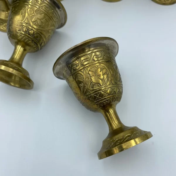 brass shot glasses close of one of six engraved design