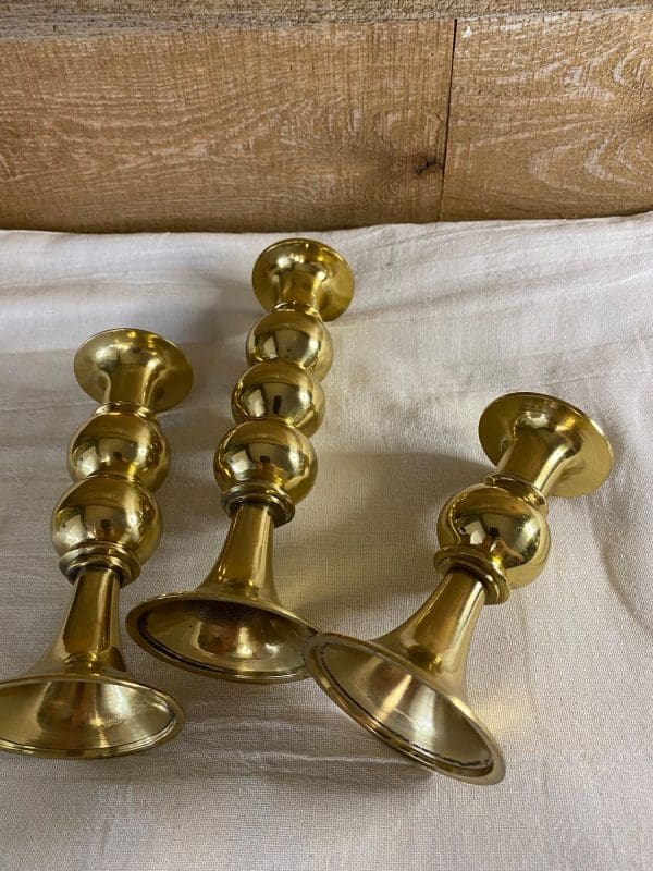 vintage brass candle holder set of three laying on sides