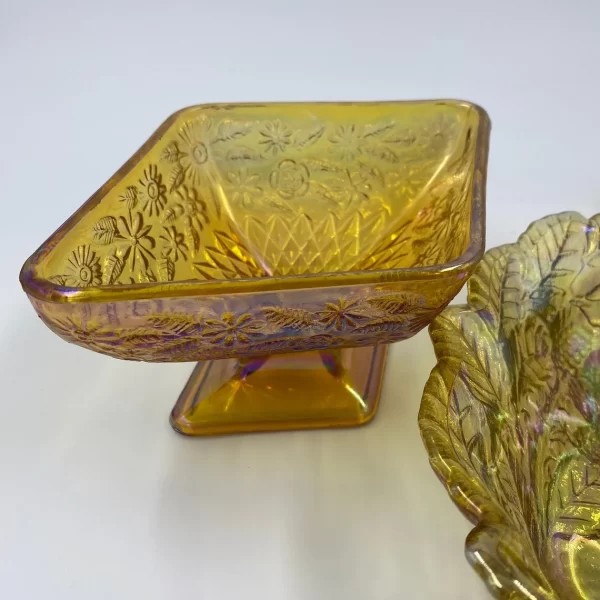 marigold carnival glass close of diamond shape pedestal dish with floral embossment