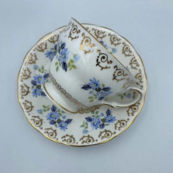 vintage Cloclough bone china tea cup and saucer with blue flowers and gold trim on white