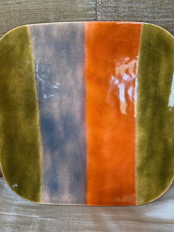 copper enamel plates close showing stripes in green orange and violet