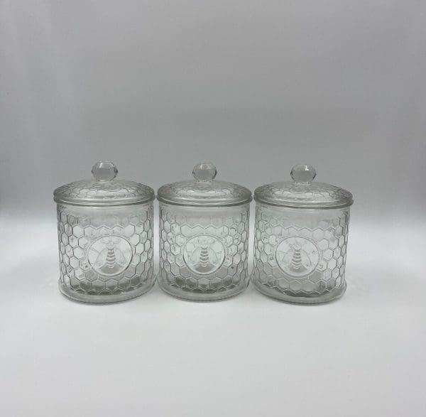 honeycomb canister with honey bee on front clear embossed glass front next to each other