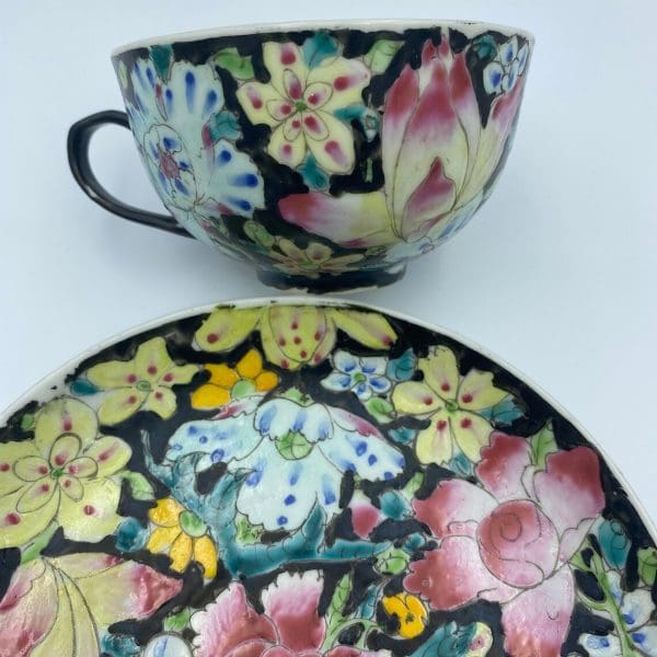 black tea cups side of tea cup close of multi color flowers