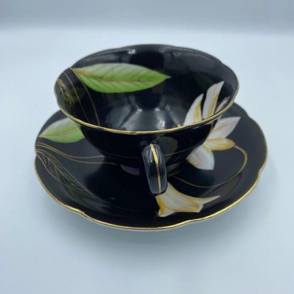 Occupied Japan tea cup and saucer black with lily flower handle