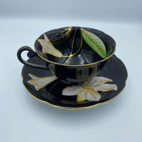 Occupied Japan tea cup and saucer black with lily flower left side