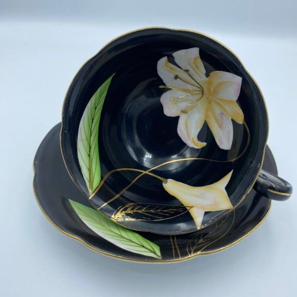 Occupied Japan tea cup and saucer black with lily flower inside