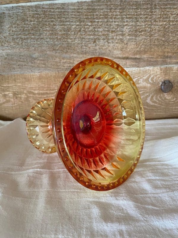 red and yellow glass candy dish on side