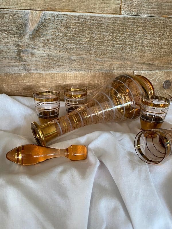 amber glass decanter with stopper gold and white stripes and four matching cups on side stopper off