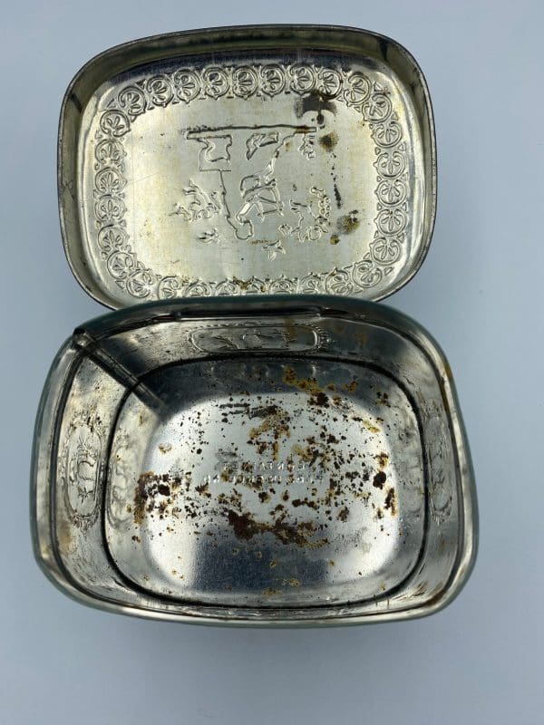 vintage candy tin Greek embossed design inside showing surface rust