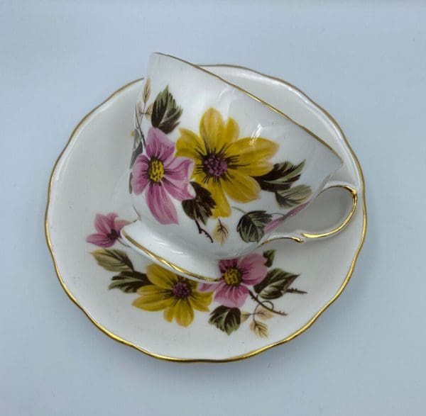 Royal Vale bone china tea cup on side top of saucer pink yellow cosmos