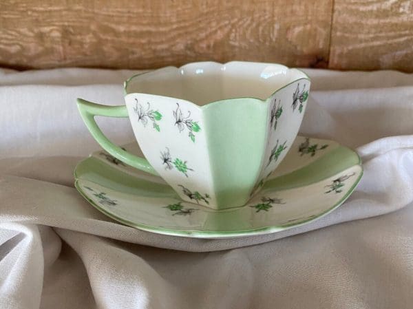 rare Shelley tea cups left side mint green panels whit white panels floral design, clovers